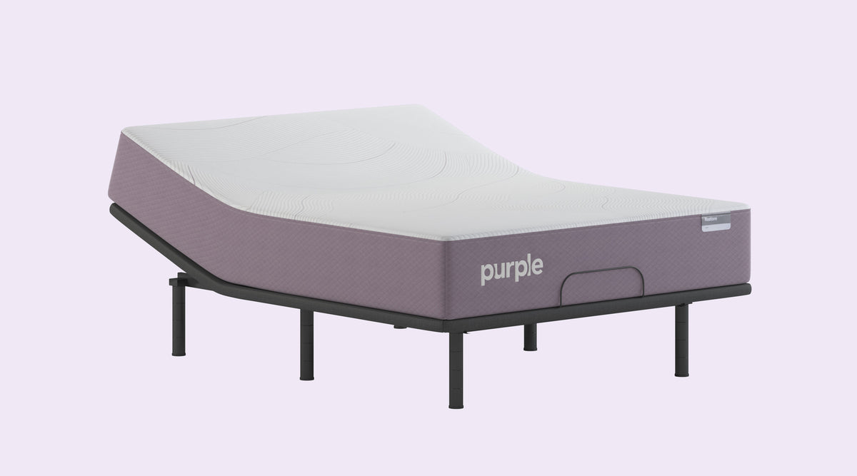 Purple mattress on a black frame against a plain background