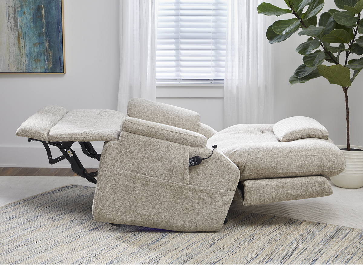 Beige recliner chair in a living room setting with a plant and abstract art on the wall.
