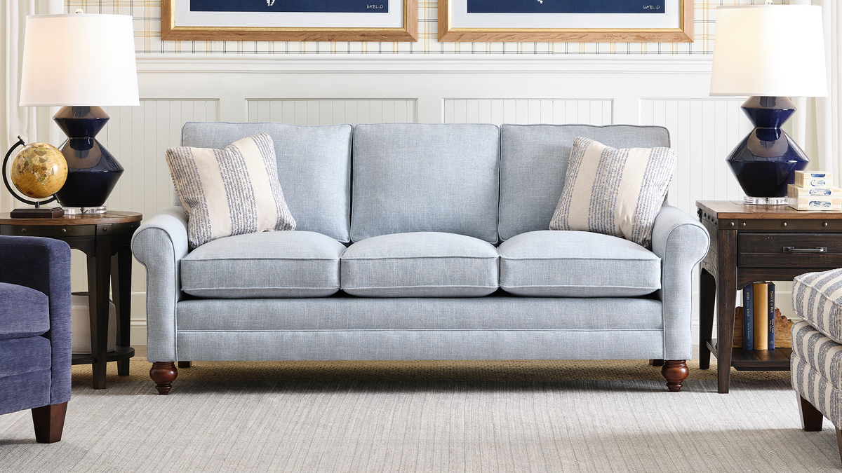 Living room with a light blue sofa, armchair, and side tables.