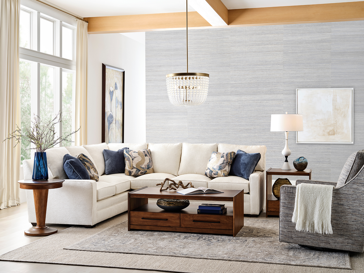 Modern living room with a white sectional sofa, wooden coffee table, and decorative items.