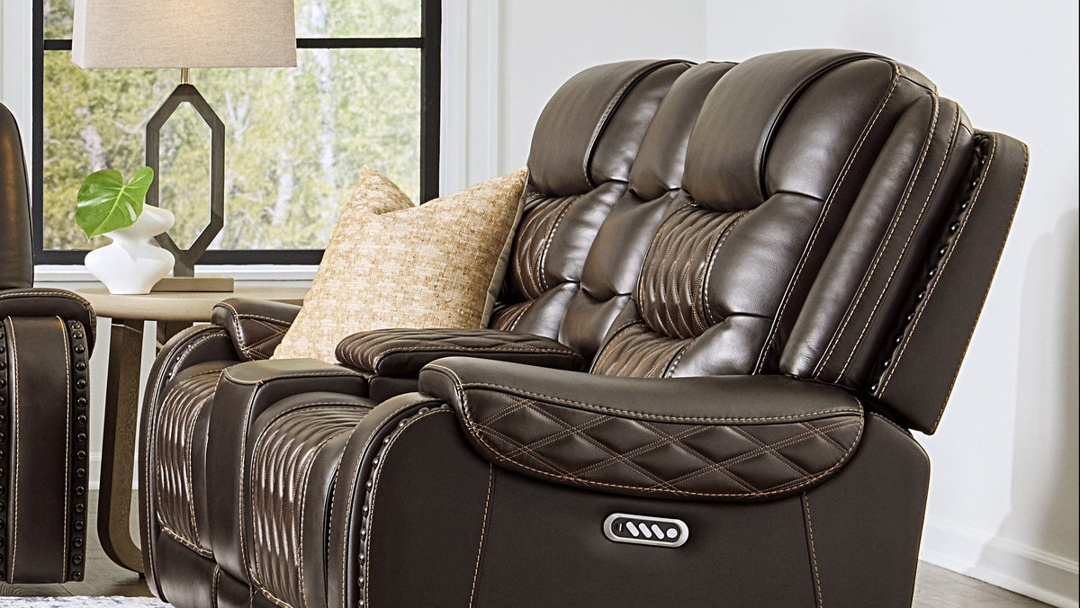 Brown leather recliner chair in a living room setting with a lamp and decorative items.