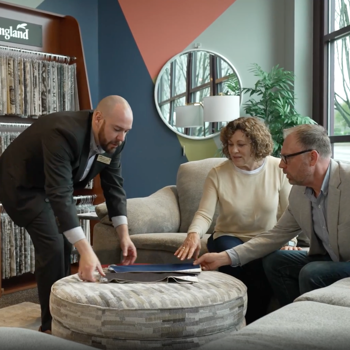 Salesperson showing a product to a couple in a home decor store.
