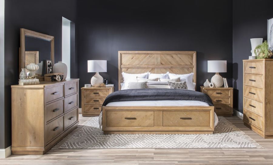 Wooden bedroom set with bed, dressers, and nightstands against a dark wall.